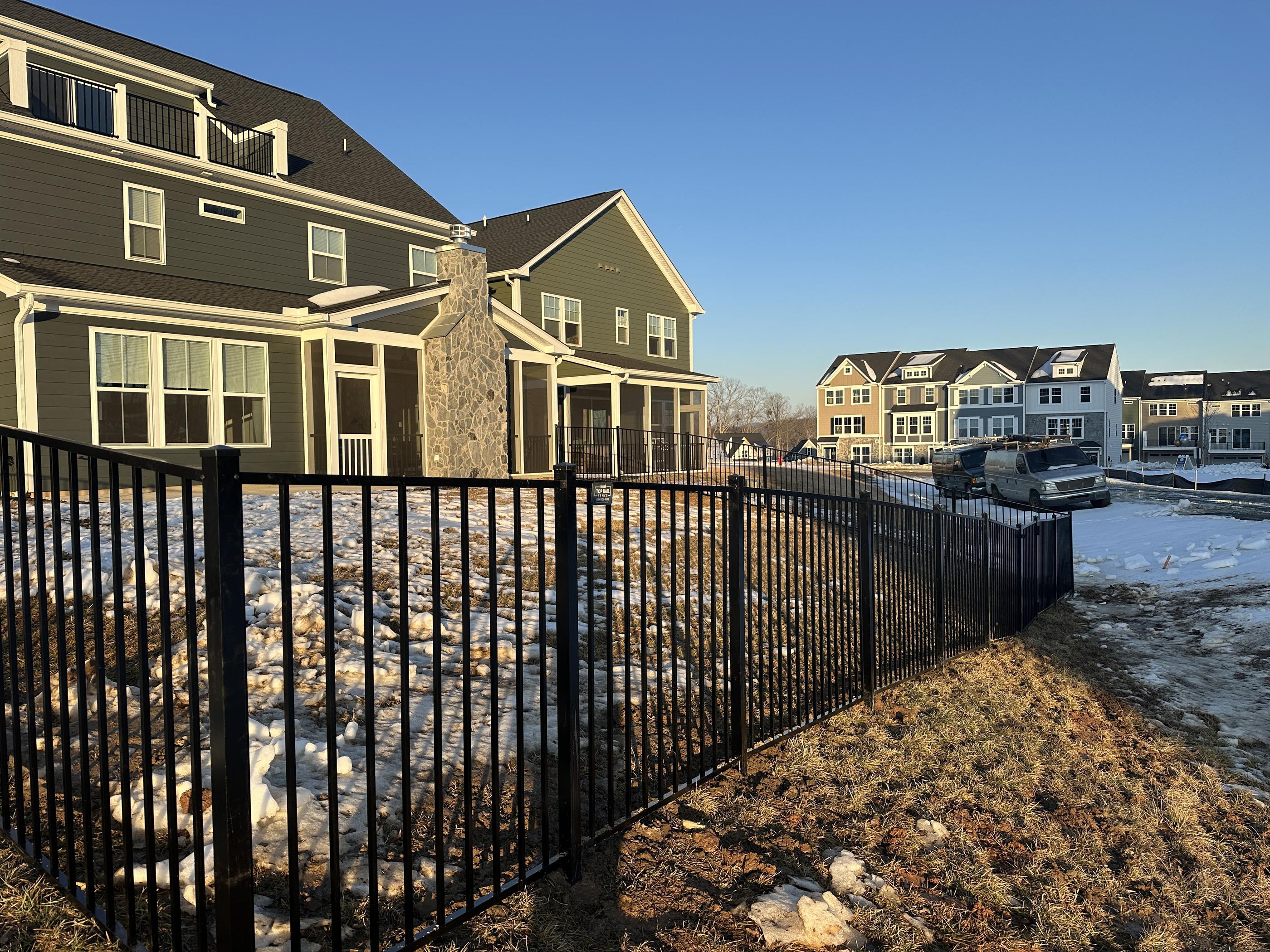 ornamental metal fence installed by top rail fence