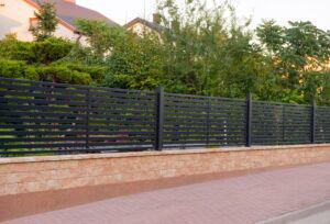 Steel metal fence with brick masonry along the bottom