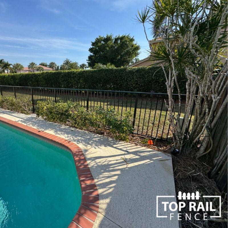 Black aluminum fence around a pool