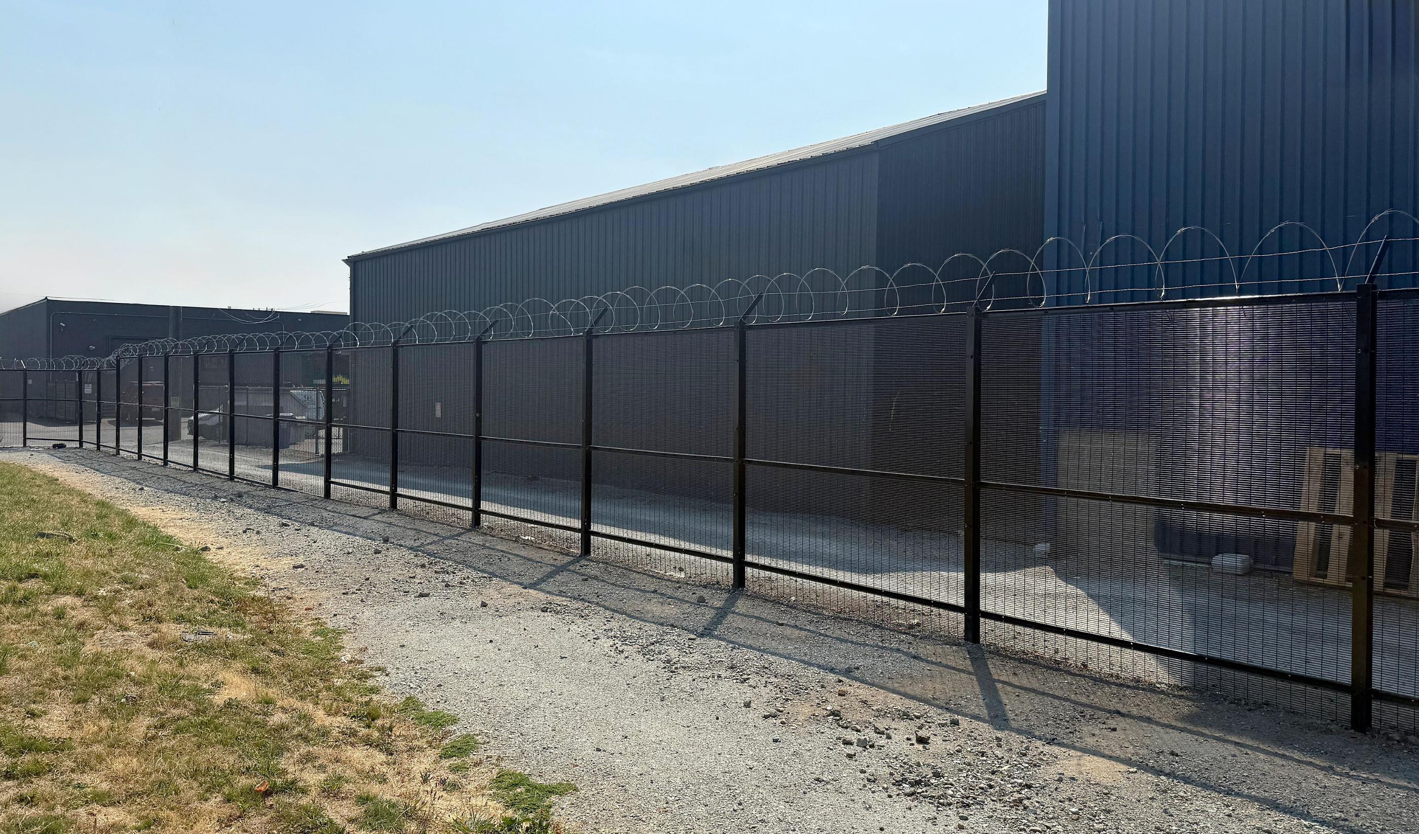 black commercial fence installed by top rail fence