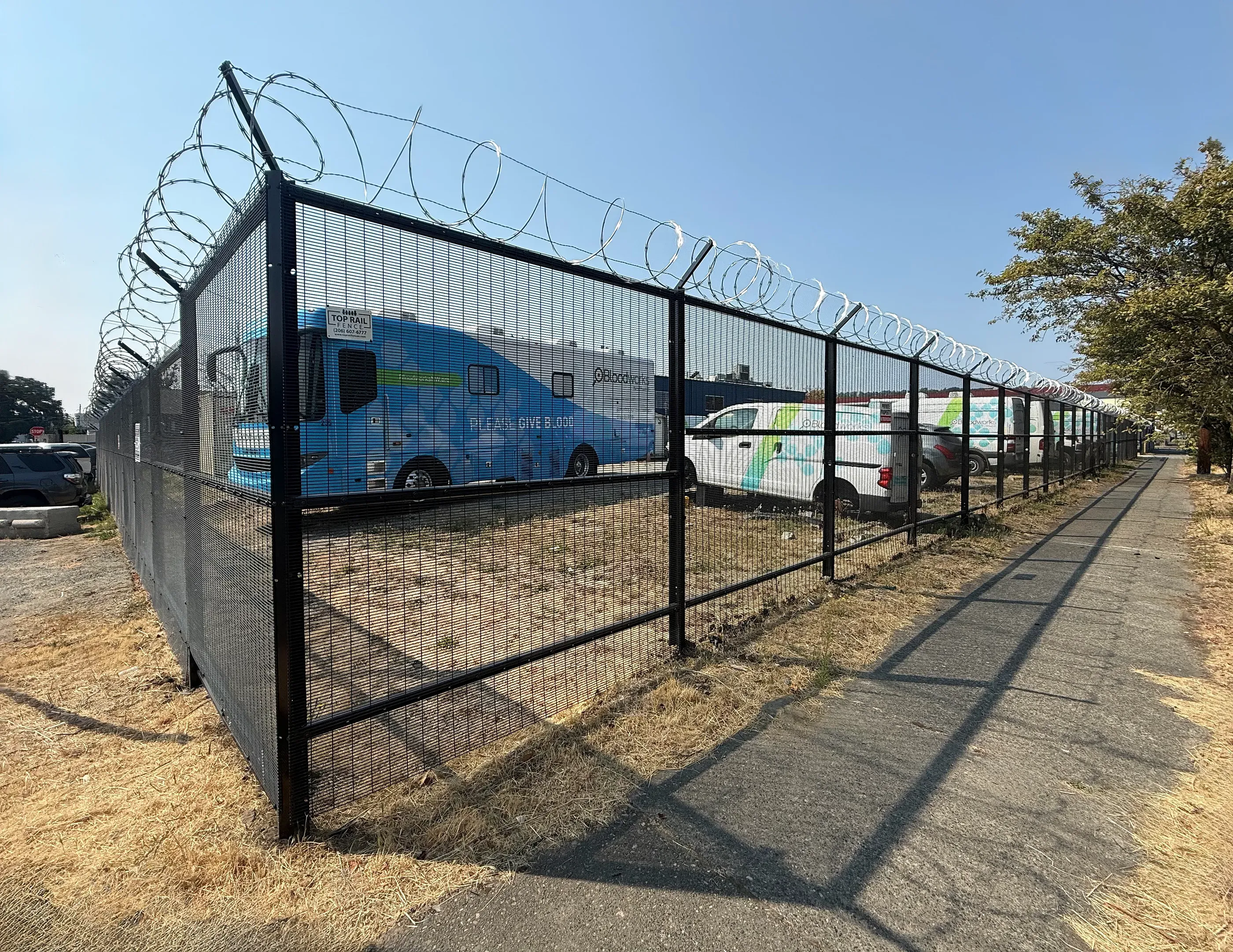 black commercial fence installed by top rail fence