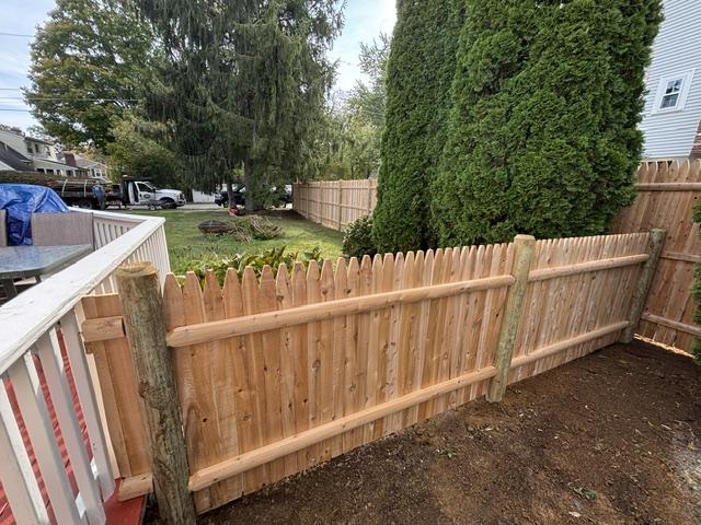 new wood stockade fence installed by top rail fence