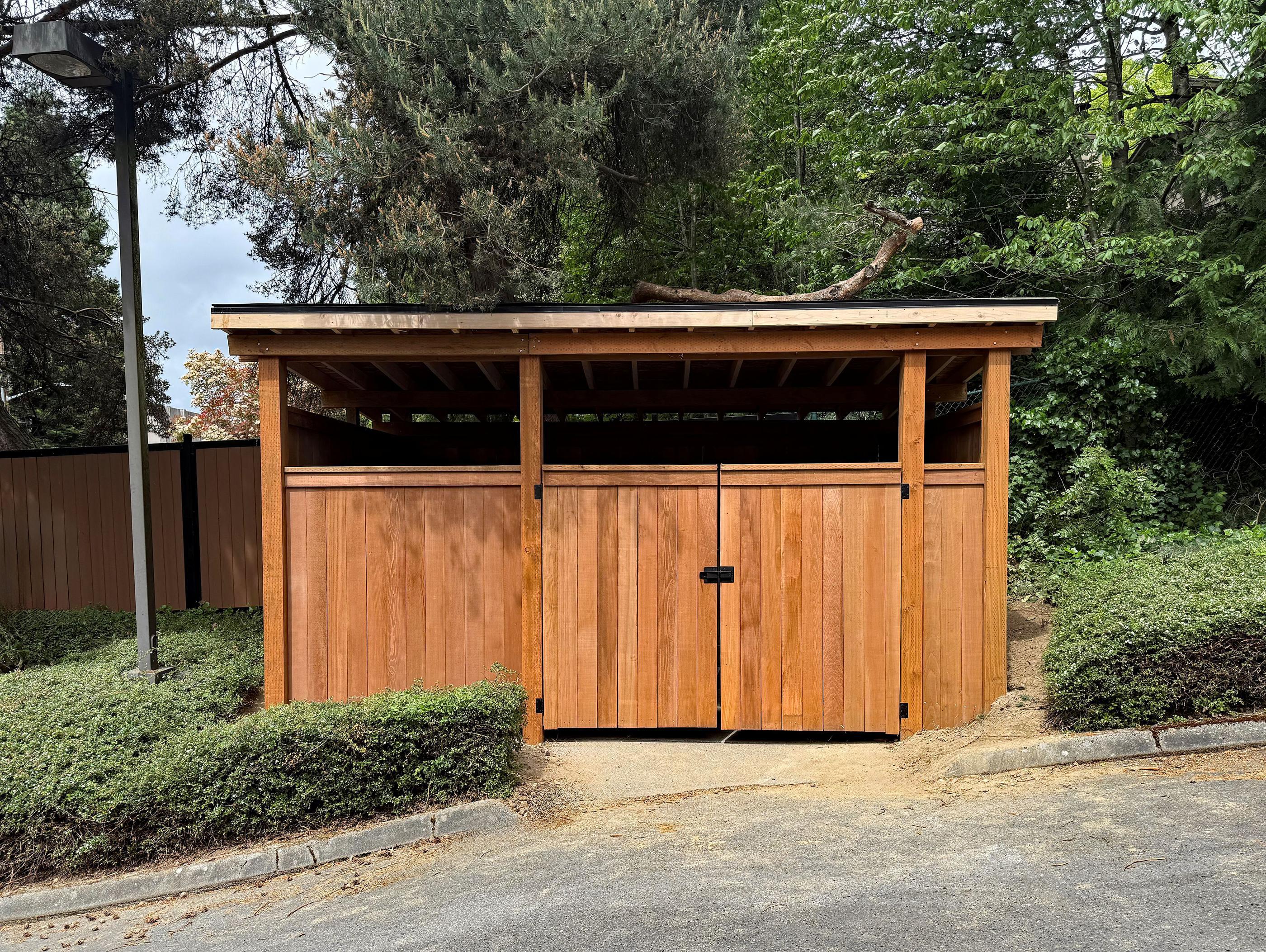 wood dumpster enclosure installed by top rail fence