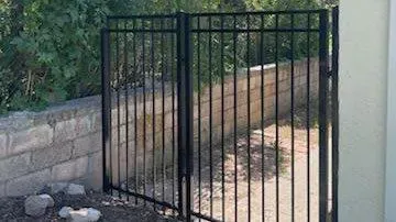 black ornamental metal fence installed by top rail fence