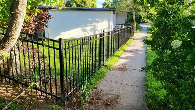 black ornamental metal fence installed by top rail fence