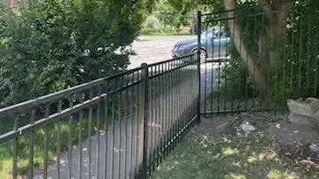 black ornamental metal fence installed by top rail fence