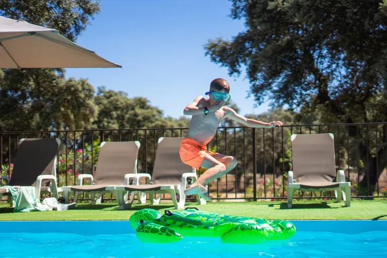 kid jumping onto floatie in pool