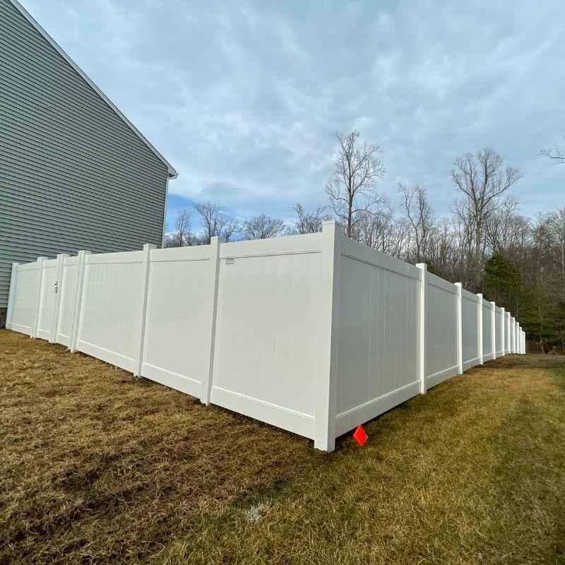 Corner of new vinyl fence installation by Top Rail Fence