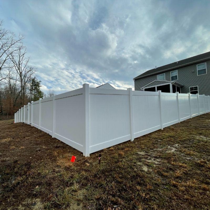 Corner of new vinyl fence installation by Top Rail Fence