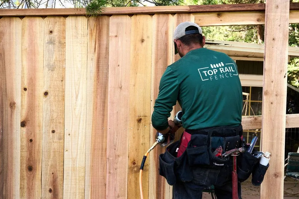 employee prepping fence
