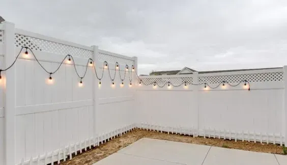 white vinyl fence with lattice top and wire lights