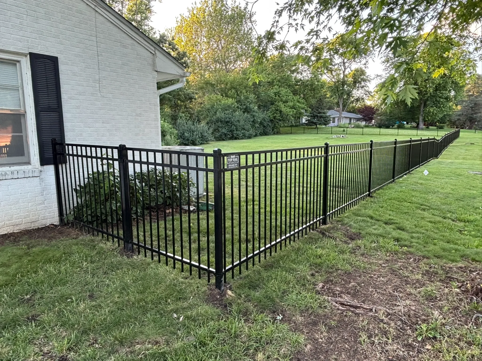 ornamental metal fence installed by top rail fence