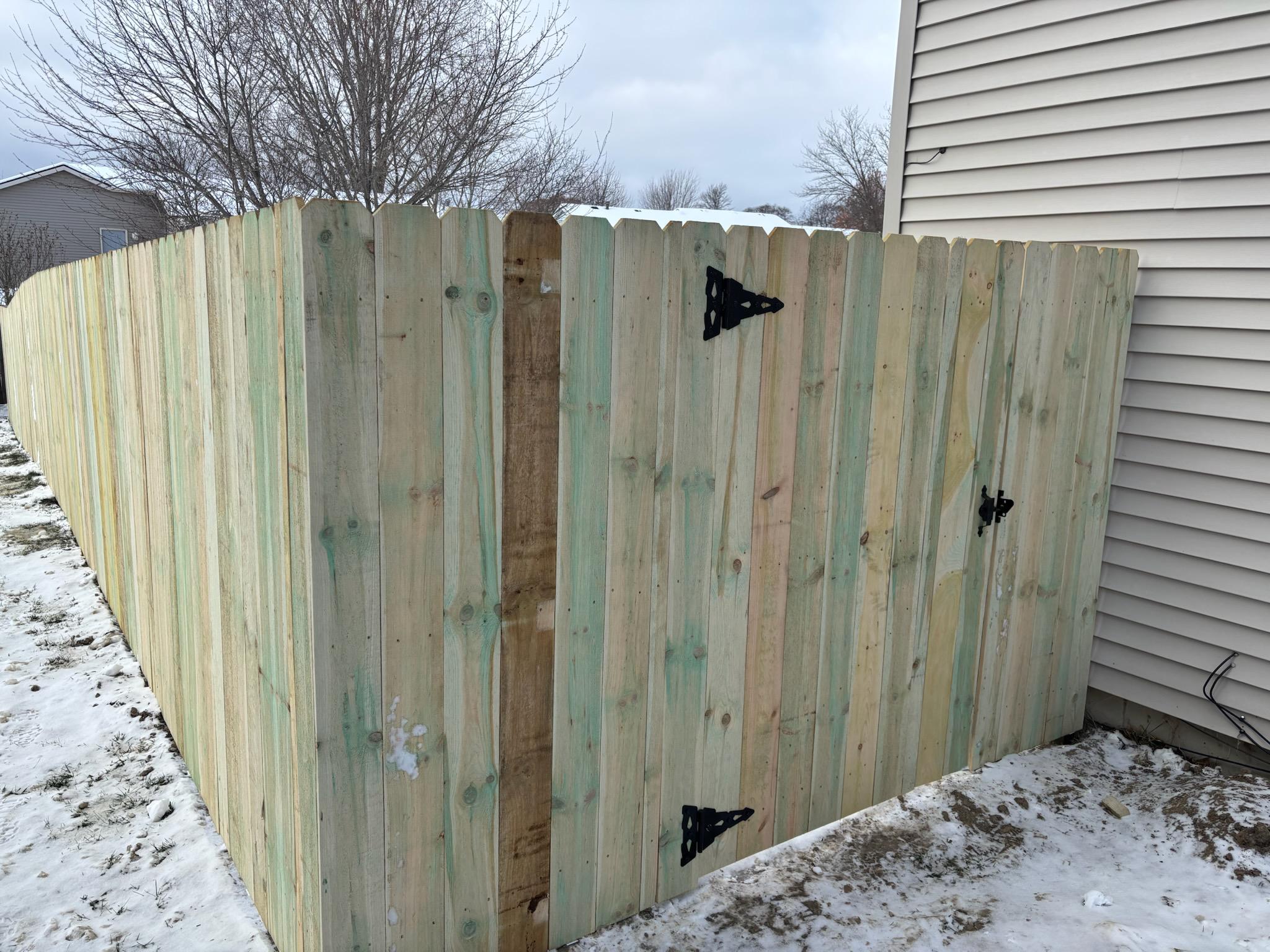 wood stockade fence with gate installed by top rail fence