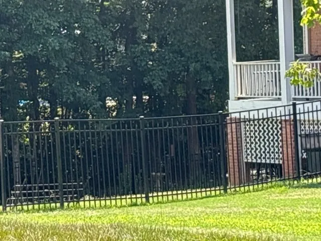 three rail ornamental metal fence installed by top rail fence