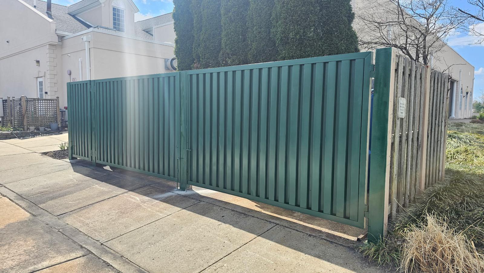 dumpster enclosure installed by top rail fence