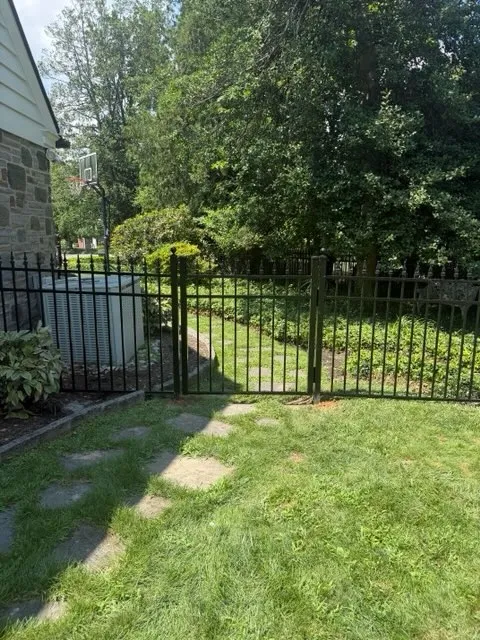 ornamental metal picket gate installed by top rail fence