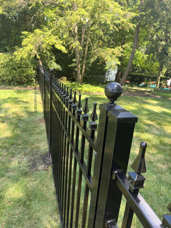ornamental metal picket gate installed by top rail fence