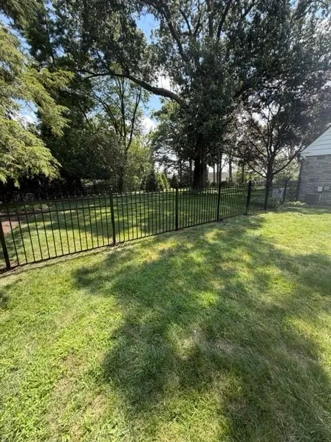 ornamental metal picket gate installed by top rail fence