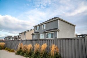 Gray vinyl fence with home behind it