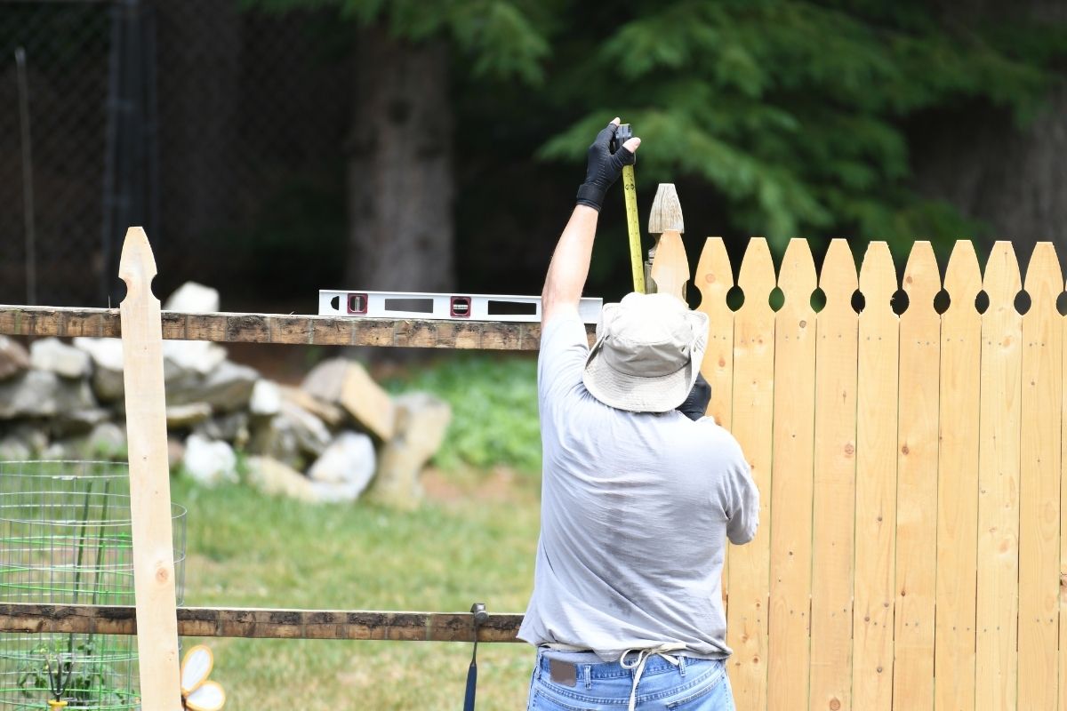Man installing a wood fence