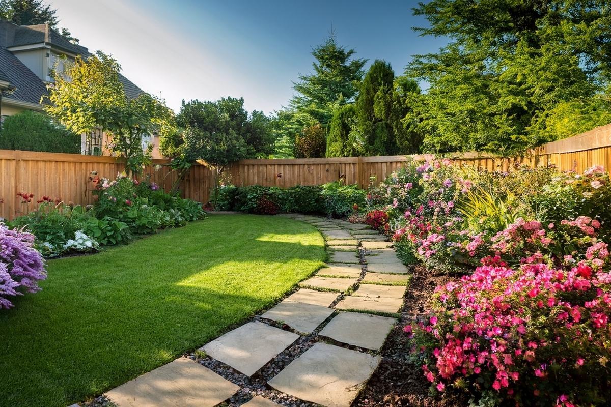 Residential backyard with landscaping, walking path and wood fence