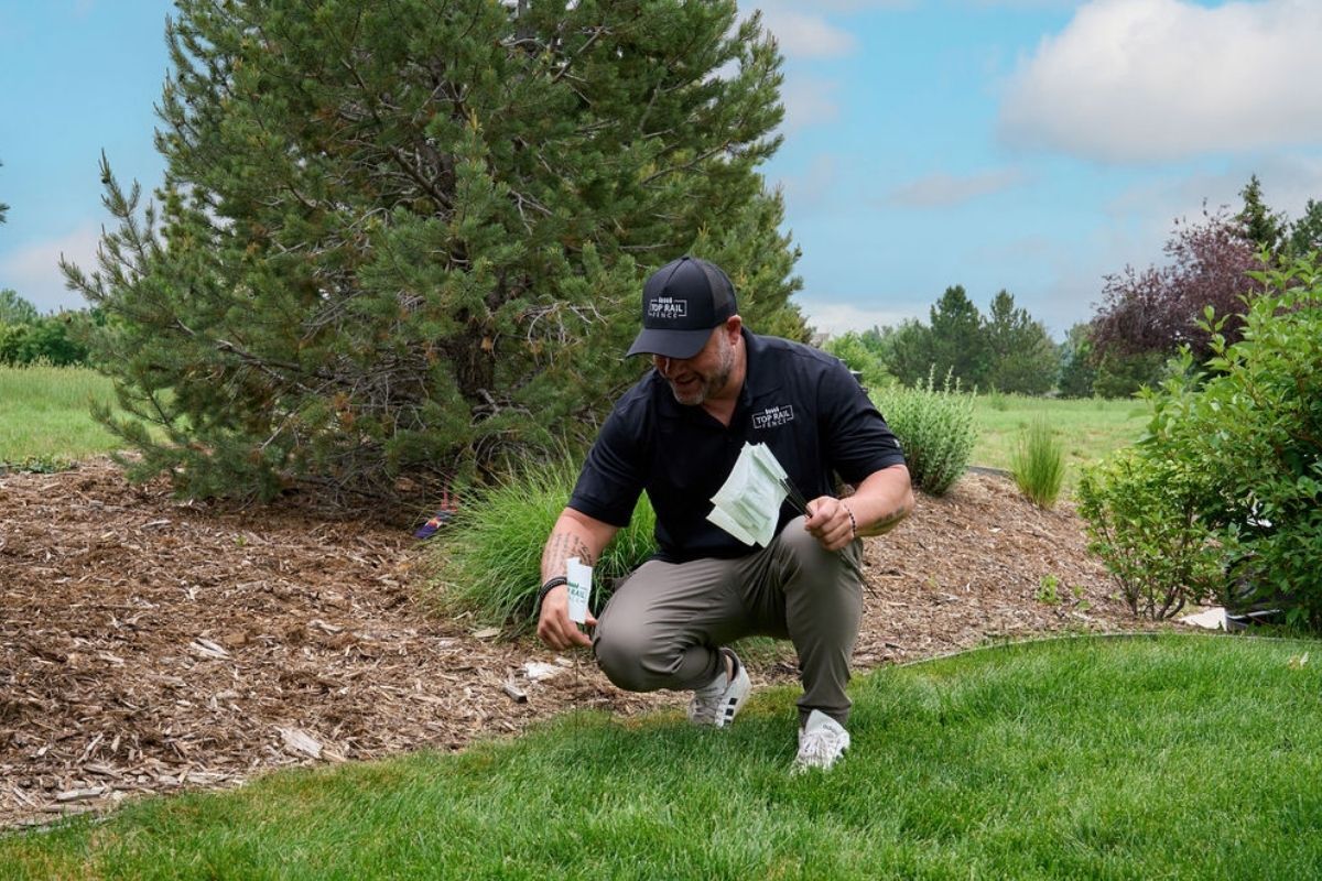 Top Rail Fence employee marking the fence line.