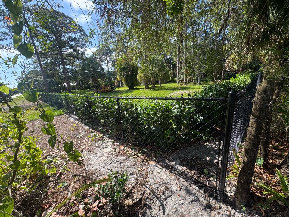 In the Pennock Point neighborhood of Jupiter, FL, we installed 600 feet of black chain link fencing—a combination of 4-foot and 6-foot heights—to help the property owner secure and protect his land. We also managed the entire permitting process to keep things simple. 