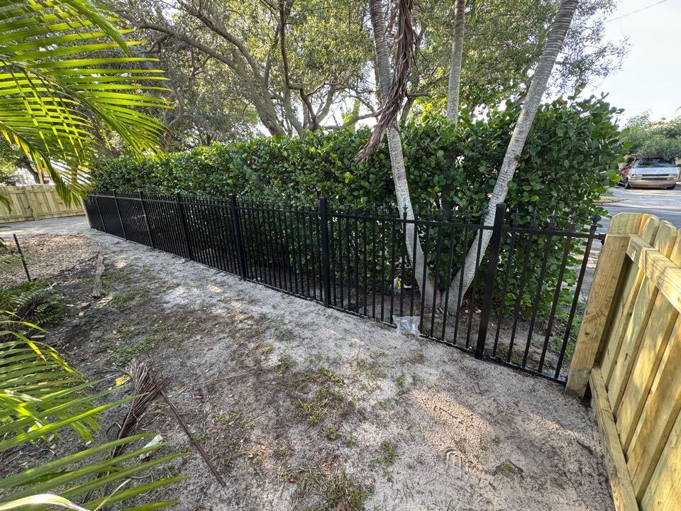 In Historic West Palm Beach, we completed over 200 feet of wood board-on-board fencing at both 6-foot and 4-foot heights, along with a custom double driveway gate and a 30-foot section of black ball quad-top aluminum. This project came with tight restrictions under the historic building code, but our team navigated the permit process from start to finish to ensure full compliance. 