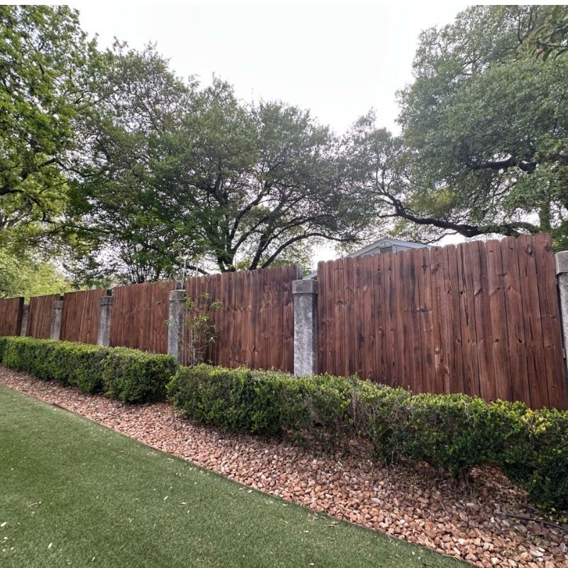 Dark stain wood stockade privacy fence with stone pillars