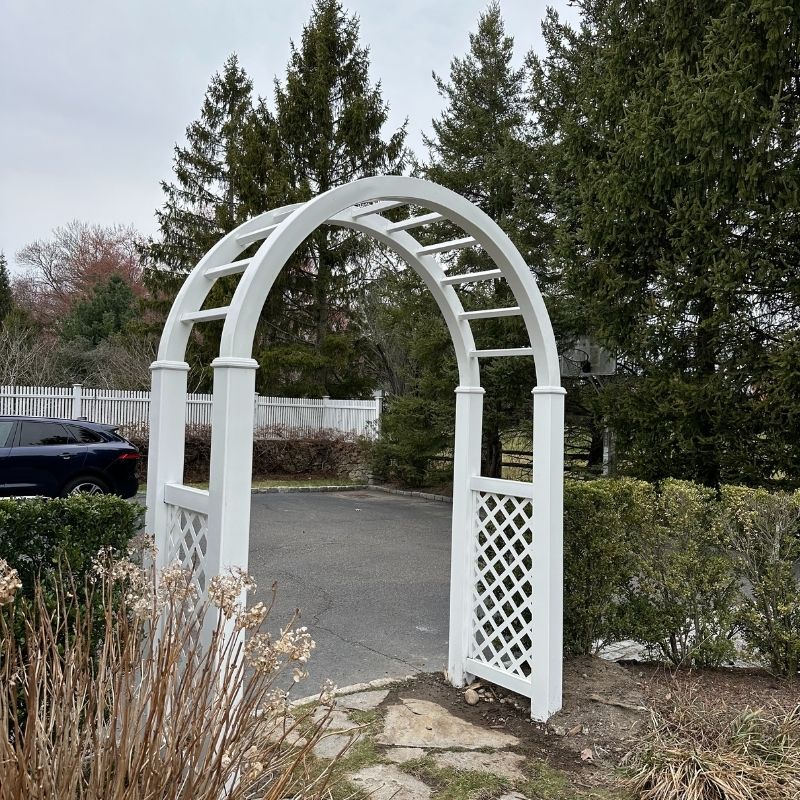 A new white vinyl arbor and replacement of a cedar arbor top, painted white by Top Rail Fence