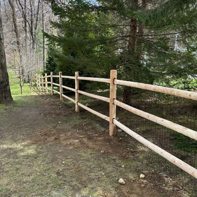 cedar round post and rail fence with heavy duty welded wire installed by Top Rail Fence