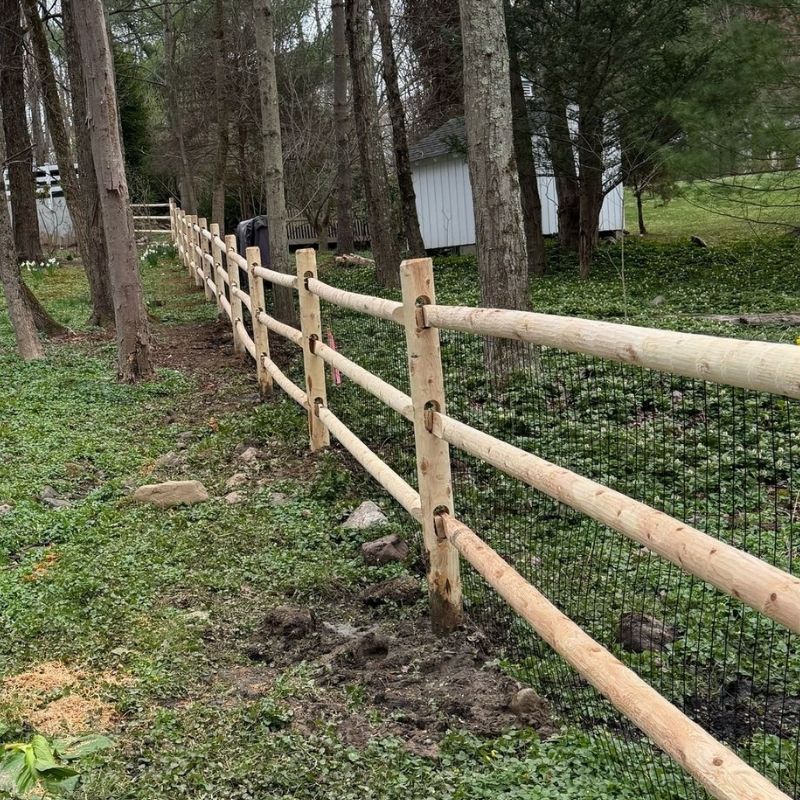 cedar round post and rail fence with heavy duty welded wire installed by Top Rail Fence