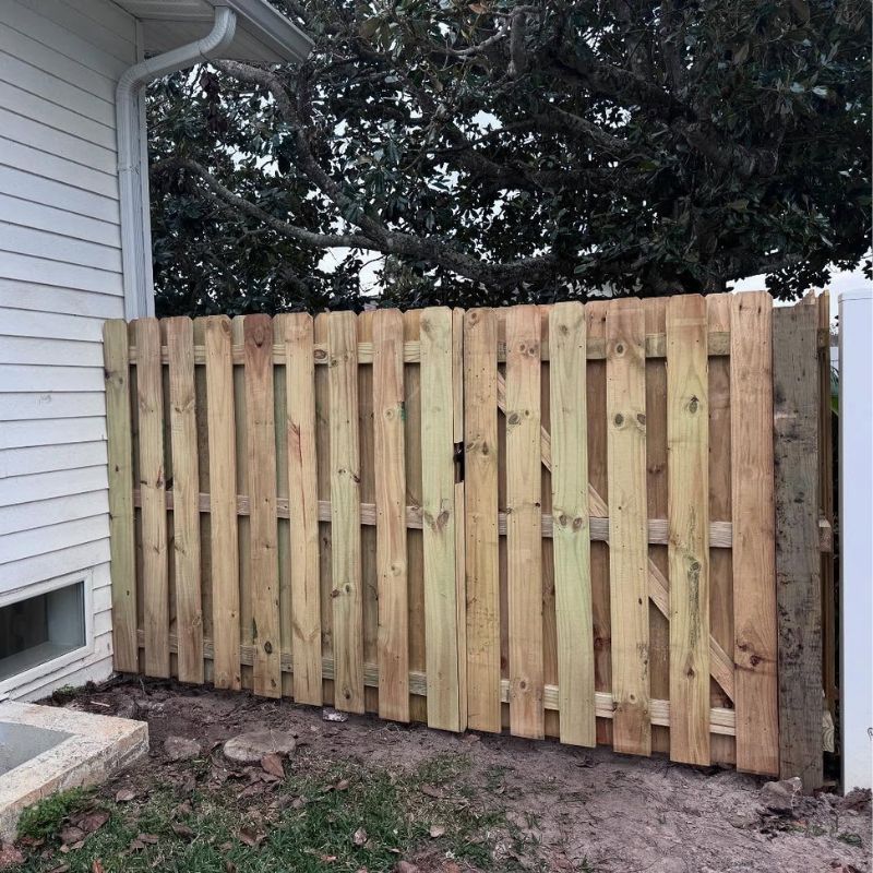 Shadowbox wood fence connecting to a house