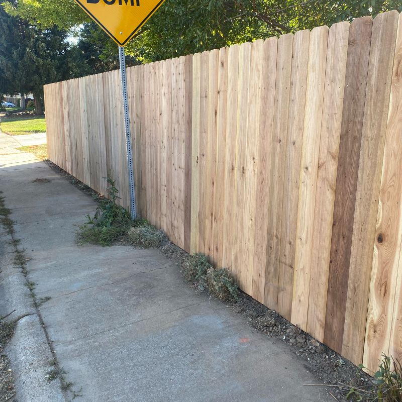 New wooden fence along sidewalk