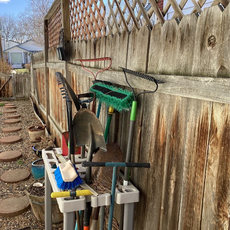 Wood fence with yard work equipment