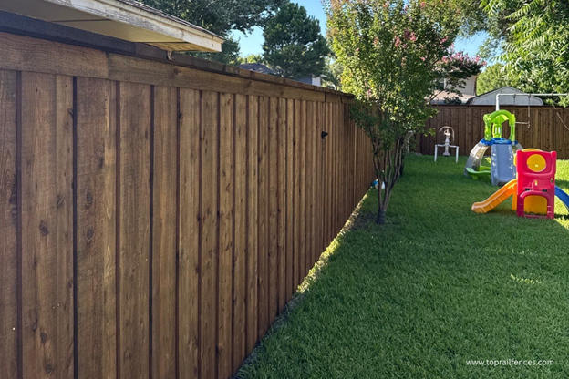 Custom board on board fence installed by Top Rail Fence in backyard setting