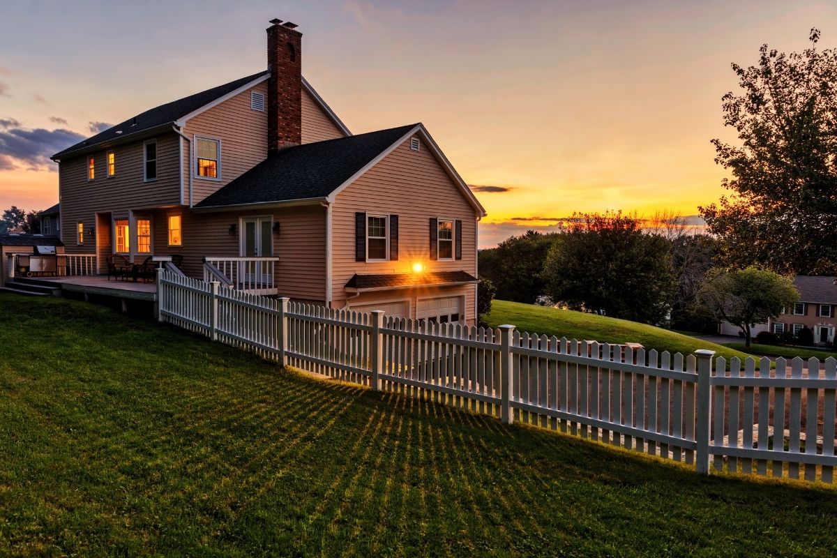 A suburban home in the evening with a picket fence