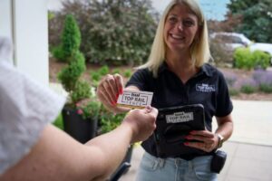 saleswoman at door with business card