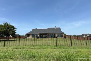 Ornamental metal fence installed by Top Rail Fence around a backyard