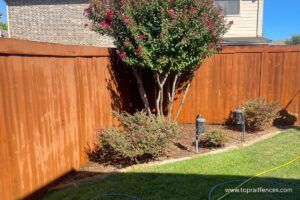 Wood fence installed by Top Rail Fence with landscaping