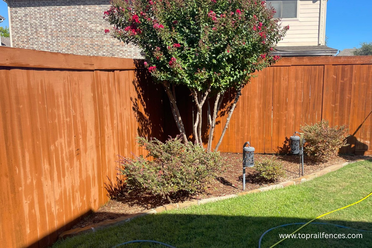 Wood fence installed by Top Rail Fence with landscaping